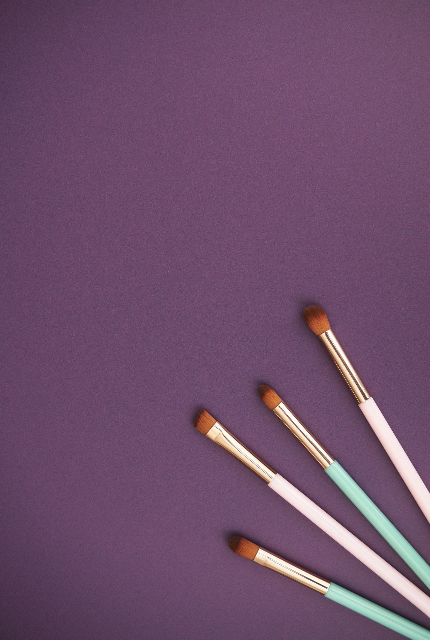 Makeup brushes on a purple background