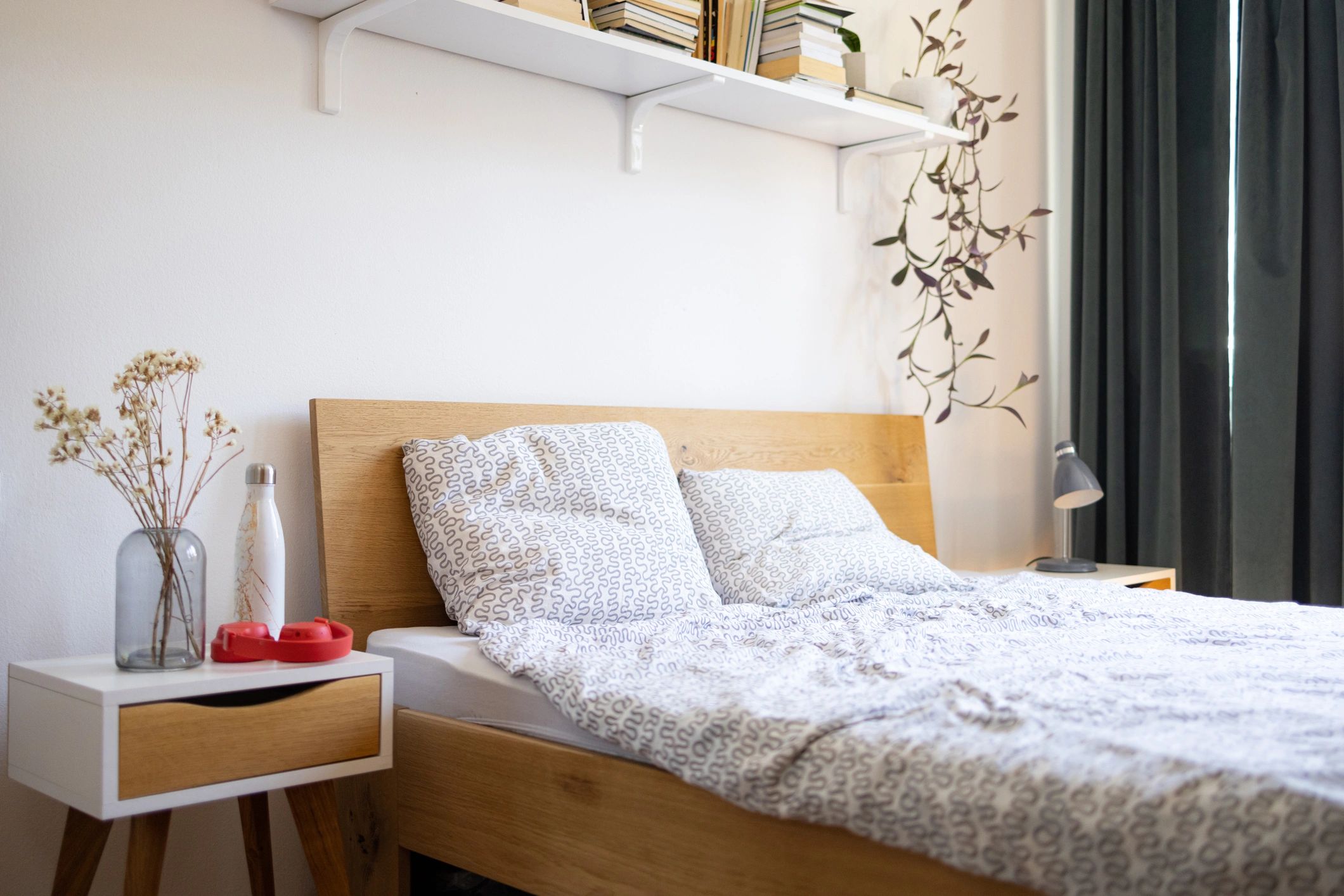 Neatly made bed with layered linens in a softly styled bedroom