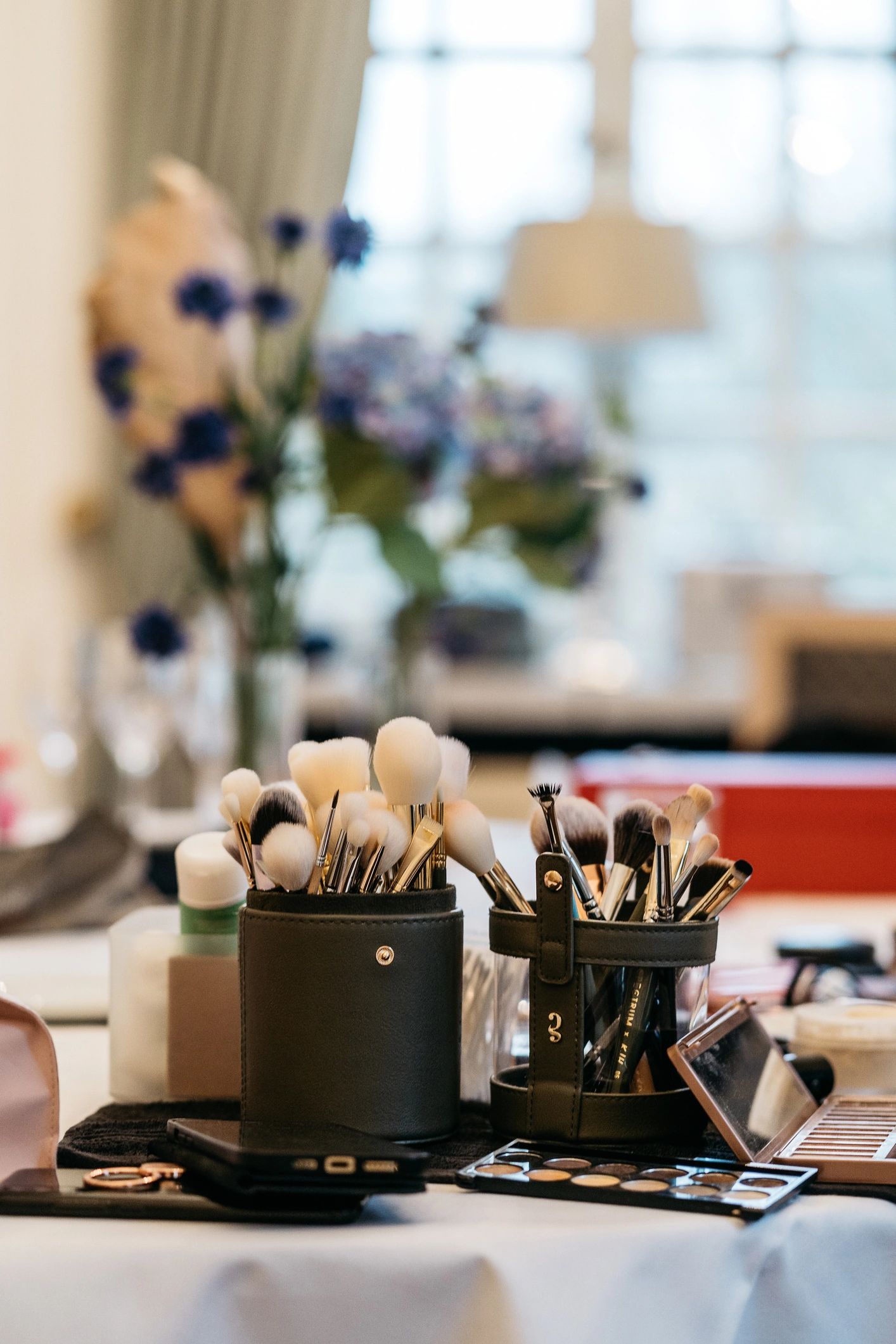 Makeup brushes and cosmetics with purple flowers