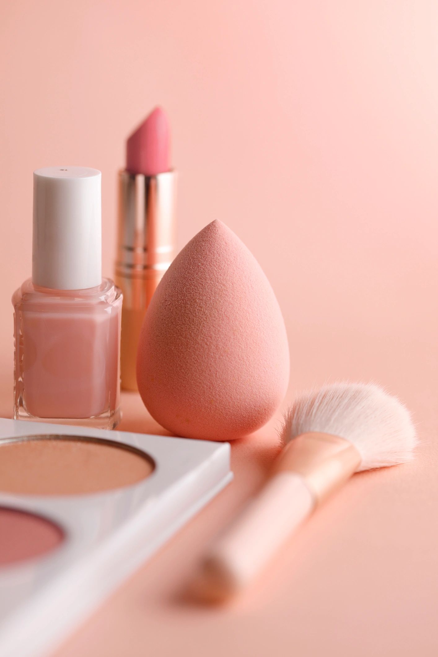 Pastel makeup arranged with a brush and blending sponge