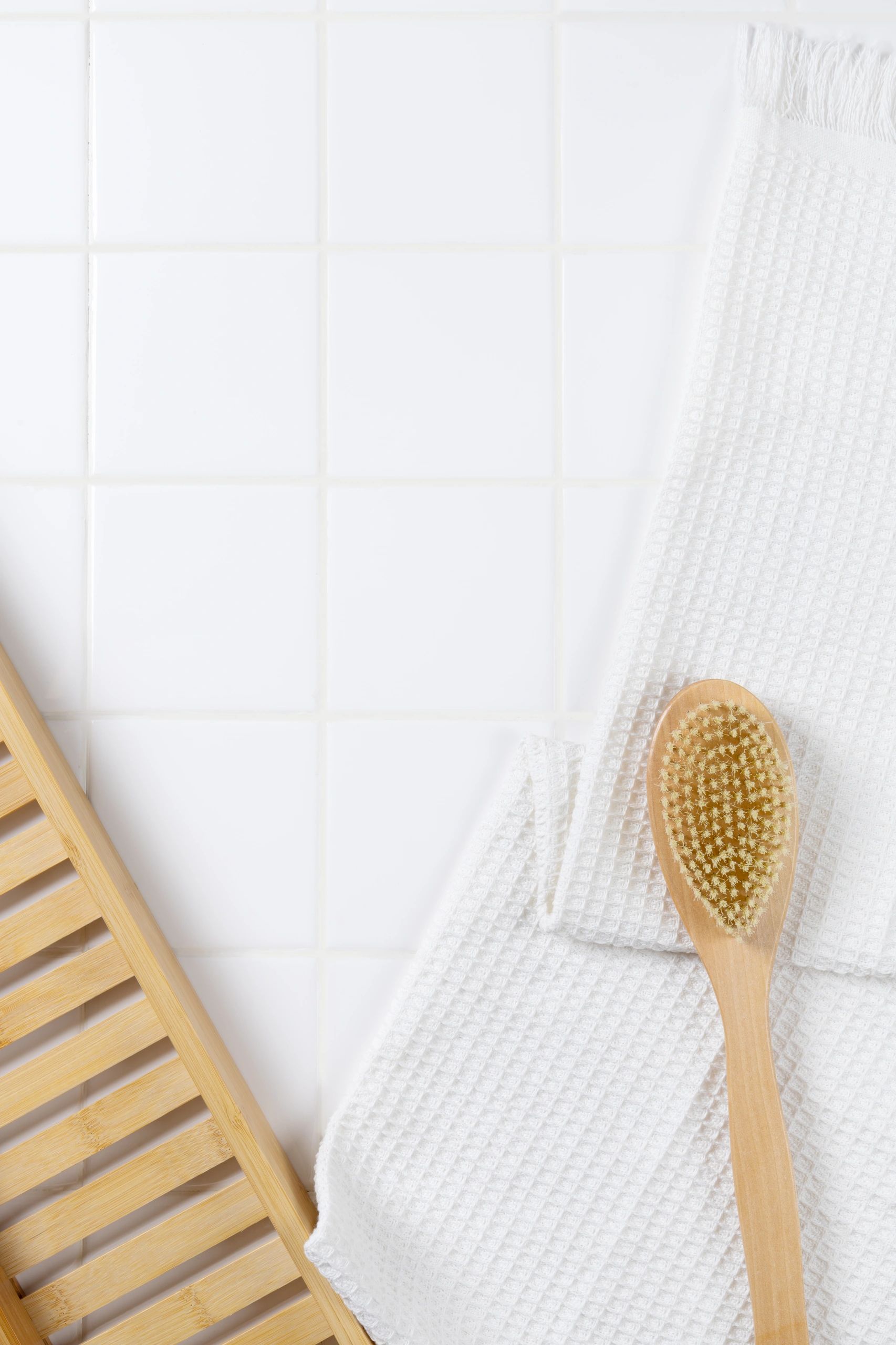 Bathroom beauty essentials arranged on white tile