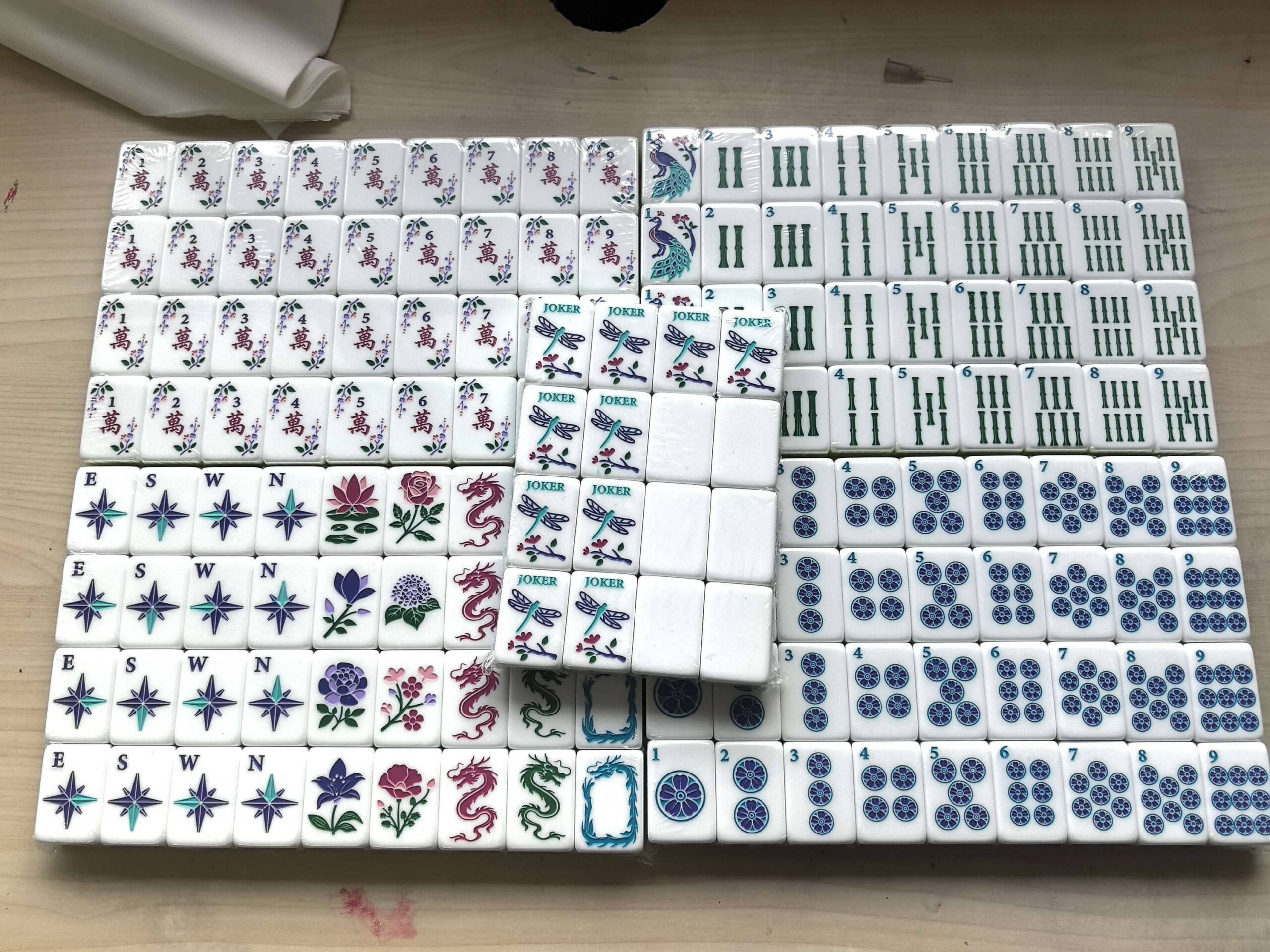 Full Botanical Mahjong tile set arranged on a wooden tabletop